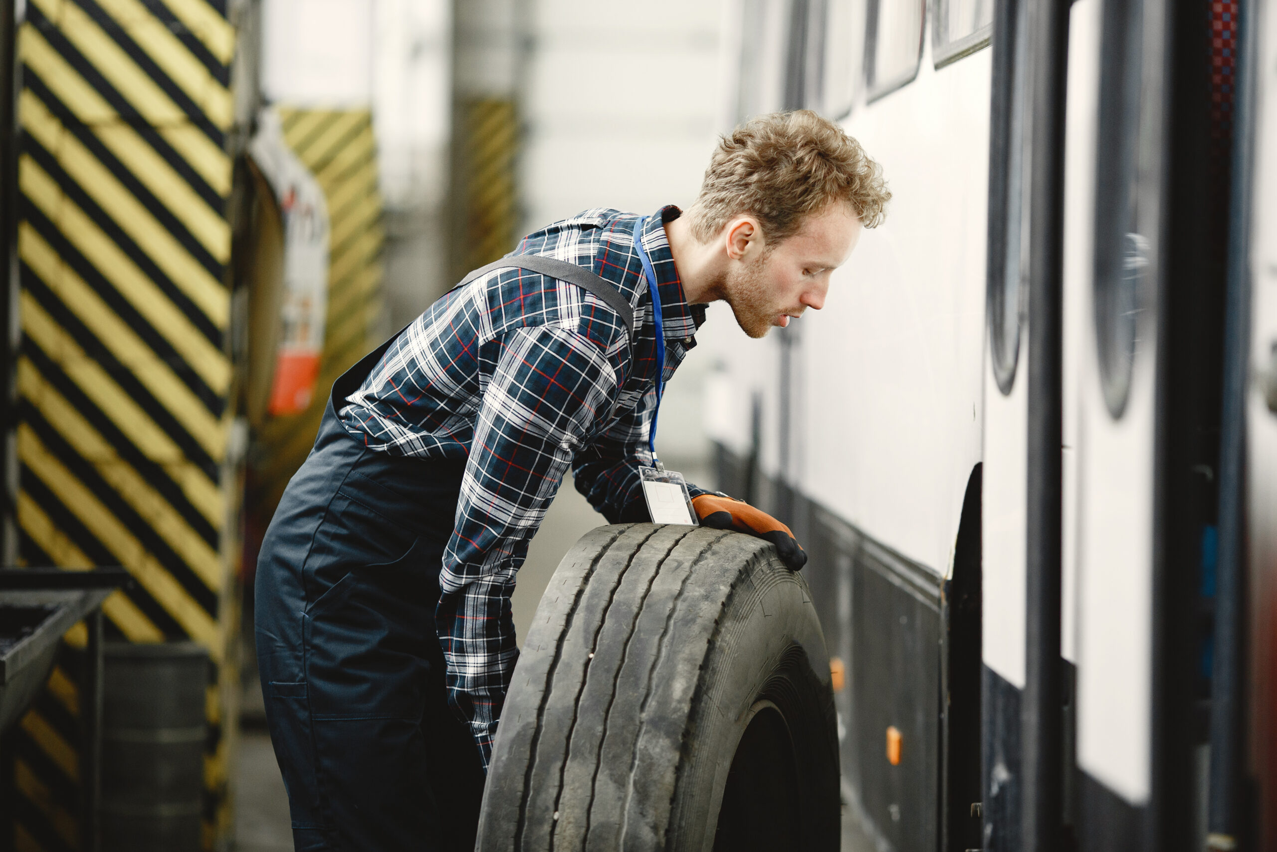 Worker with a wheel. Wheel replacement. Man in uniform