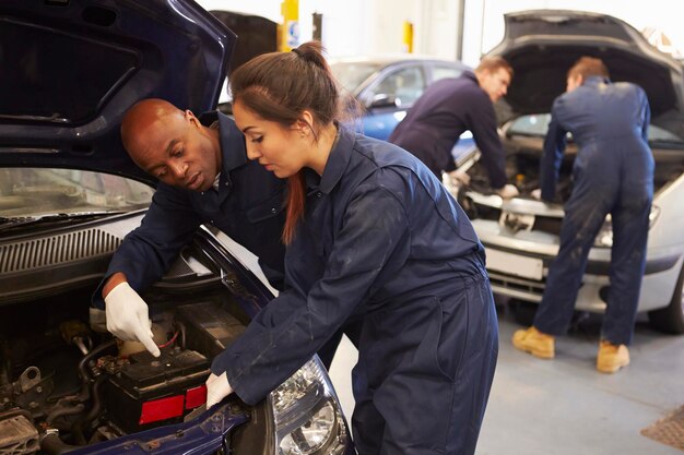 teacher-helping-student-training-be-car-mechanics